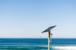 Solar energy panel photovoltaic cell on the pole near the ocean. Renewable energy. Enviroinment conservation. Solar powered equipment