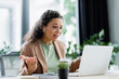 © LIGHTFIELD STUDIOS - surprised african american businesswoman gesturing during video chat on laptop in office