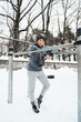 Athletic woman during her winter outdoor workout on parallel bars