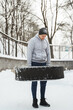 Strong sportsman during his cross-training with a tire workout during snowy and cold winter day.