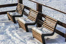 Snow-covered Benches On The Back Porch On A Winter Day.Wooden Terrace For Relaxing And Barbecue.