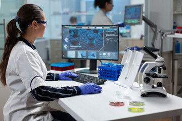 Wall Mural - Researcher biochemist woman analyzing virus expertise working on coronavirus treatment in microbiology hospital laboratory. Chemist scientist typing biomedical research. Biochemistry examination