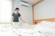 © snowing12 - Bedroom concept a female adult doing the routine by grabbing the edge of the blanket for making bed after getting up in the morning time