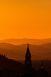 © Lars Johansson - Church tower in the sunset silhouette with mountains in the background