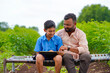 © Niks Ads - Cute indian farmer child studying with his father at home