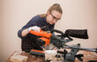 © Dima - the girl works in the carpentry. sawing boards. make furniture. copy space