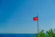 Turkish flag on the background of the sea and mountains in sunny weather. Turkey flag symbol