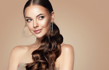 beautiful girl . fashionable and stylish woman in trendy jewelry big earrings .curly ponytail hairst