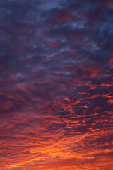 epic dramatic sunrise, sunset orange red pink clouds in sunlight on blue sky background texture