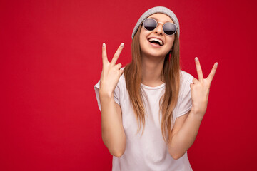 Wall Mural - Photo of young positive happy smiling beautiful hipster woman with sincere emotions wearing stylish clothes isolated over background with copy space