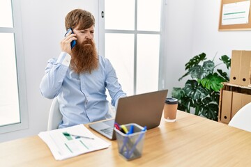 Sticker - Young irish businessman with serious expression talking on the smartphone at the office.