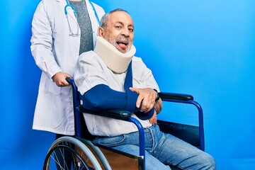 Canvas Print - Handsome senior man with beard sitting on wheelchair with neck collar sticking tongue out happy with funny expression. emotion concept.