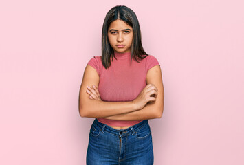 Poster - Young hispanic girl wearing casual t shirt skeptic and nervous, disapproving expression on face with crossed arms. negative person.