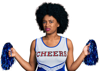 Poster - Young african american woman wearing cheerleader uniform using pompom clueless and confused expression. doubt concept.