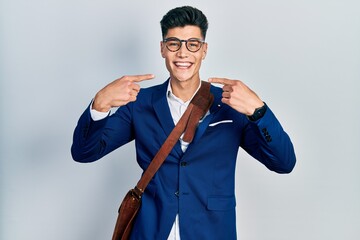 Sticker - Young hispanic man wearing business clothes smiling cheerful showing and pointing with fingers teeth and mouth. dental health concept.