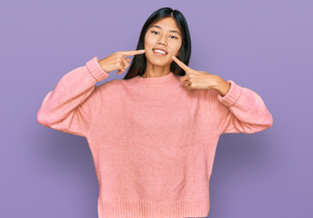 Sticker - Beautiful young asian woman wearing casual winter sweater smiling cheerful showing and pointing with fingers teeth and mouth. dental health concept.