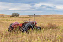 Vintage Red Tractor Abandoned In Tall Grass On The Prairies In Saskatchewan