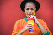 Young woman drinking cocktail during gay pride parade - LGBT community concept