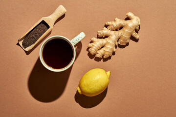 Wall Mural - Minimalistic poster - composition with tea, lemon, honey and ginger on a brown background. Healing tea for colds.