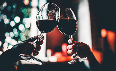 Young women hands holding glasses of red wine and clinking wine glasses in cafe or restaurant