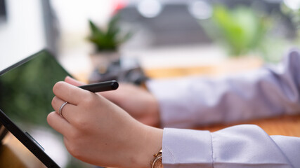 Leinwandbilder - Asian woman hand holding pen stylus writing on digital tablet computer. close up