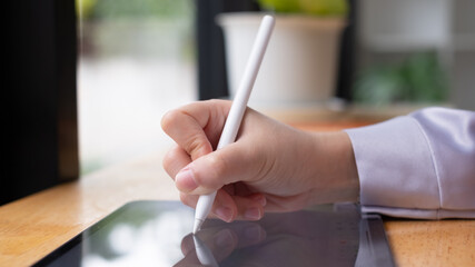 Leinwandbilder - Asian woman hand holding pen stylus writing on digital tablet computer. close up