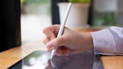 Leinwandbilder - Asian woman hand holding pen stylus writing on digital tablet computer. close up