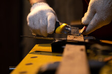 Close-up Of Carpenter Hands Use Old Sharp Utility Knife For Manual Sharpener Pencil With Fabric Glove In Warm Light Workshop, Using Snap Blade Knife To Sharpen Pencil Equipment For Marking In Work