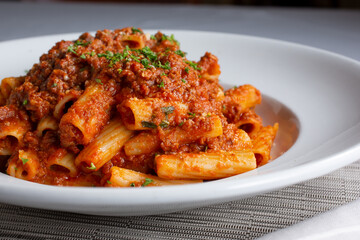 A view of a plate of rigatoni bolognese.