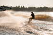Great view of active man riding wakeboard behind motor boat on splashing river waves. Active and extreme sports