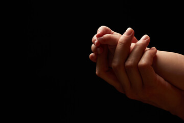 Close up newborn fingers feet and hands isolated on black background 