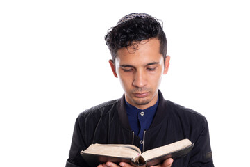 Latin man practicing Judaism isolated on white background. Young man with kippah reading bible.