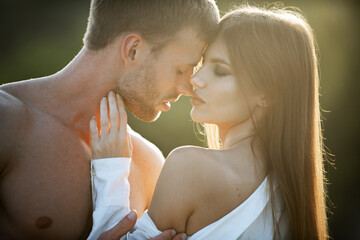 Wall Mural - Young couple in love spends time together. Man embracing and going to kiss sensual woman.