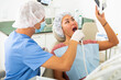 © JackF - Dentist in face mask scanning the teeth of female patient during checkup at dental clinic office