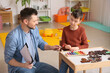 © Pixel-Shot - Male psychologist working with little boy in office. Autism concept