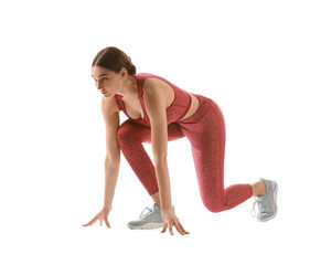 Sporty young woman in crouch start position on white background