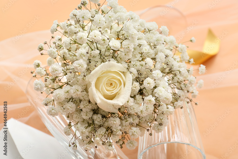 Beautiful wedding bouquet and glasses on color background, closeup