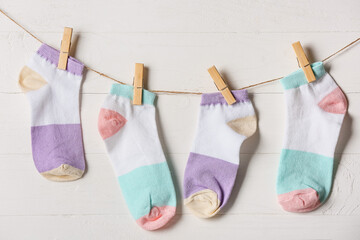 Wall Mural - Many socks hanging on rope against light wooden background