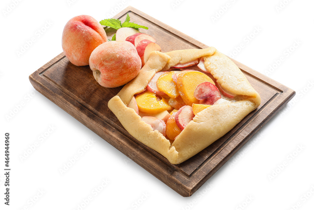 Board with raw peach galette on white background