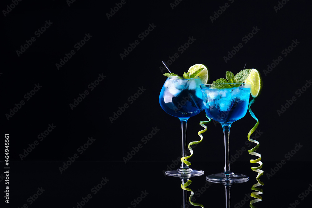 Glasses of Blue Lagoon cocktail on dark background