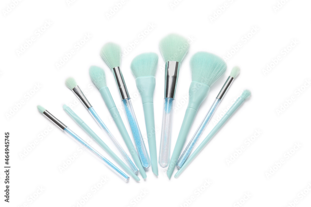 Different stylish makeup brushes on white background