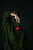 Fototapeta Mapy - Conceptual portrait of a girl in a green sweater and a red christmas ball