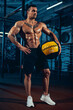 © master1305 - Portrait of handsome, sportive man, bodybuilder posing at sport gym, indoors. Concept of sport, activity, healthy lifestyle