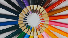Many Colored Pencils Are Arranged Around The Edges Of The Image As A Frame. In The Center Is An Empty Background With Space For Text. Mock Up With Copy Space.