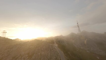 Wall Mural - FPV video, mountain surfing, flying at high speed in the clouds with a granitic mountain range and an antenna farm during a beautiful sunrise. Mount Limbara (Monte Limbara) Tempio Pausania, Sardinia, 