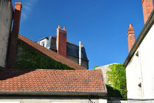 View Of Roofs & Chimneys In French Village Against Blue Sky 
