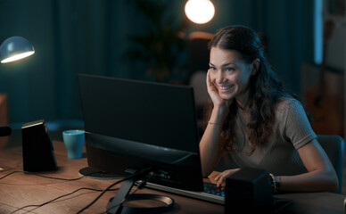 Happy young woman connecting online at night