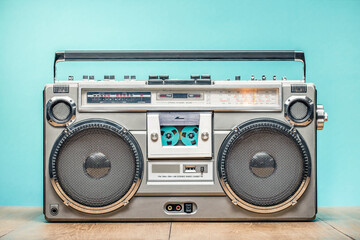 Wall Mural - retro outdated portable cassette tape recorder from 80s on wooden table front mint blue wall backgro
