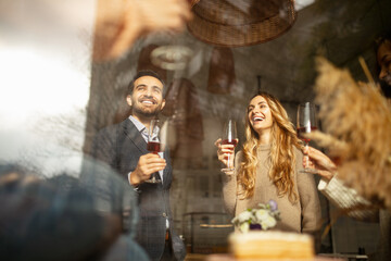 Wall Mural - Cropped portrait of laughing friends celebrating event at cafe, clinking wine glasses, saying toasts