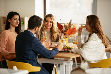 Wall Mural - Cropped portrait of friends, man and three women celebrating event at cafe